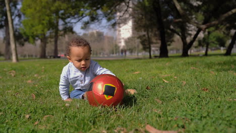 Junge-Spielt-Mit-Ball,-Versucht-Ihn-Hochzuheben-Und-Beißt-Ihn